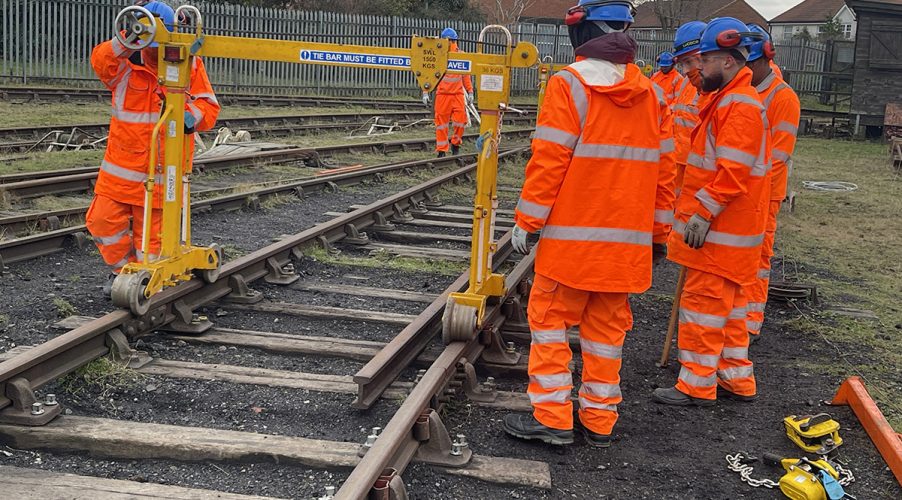 Rail workers moving equipment across the tracks