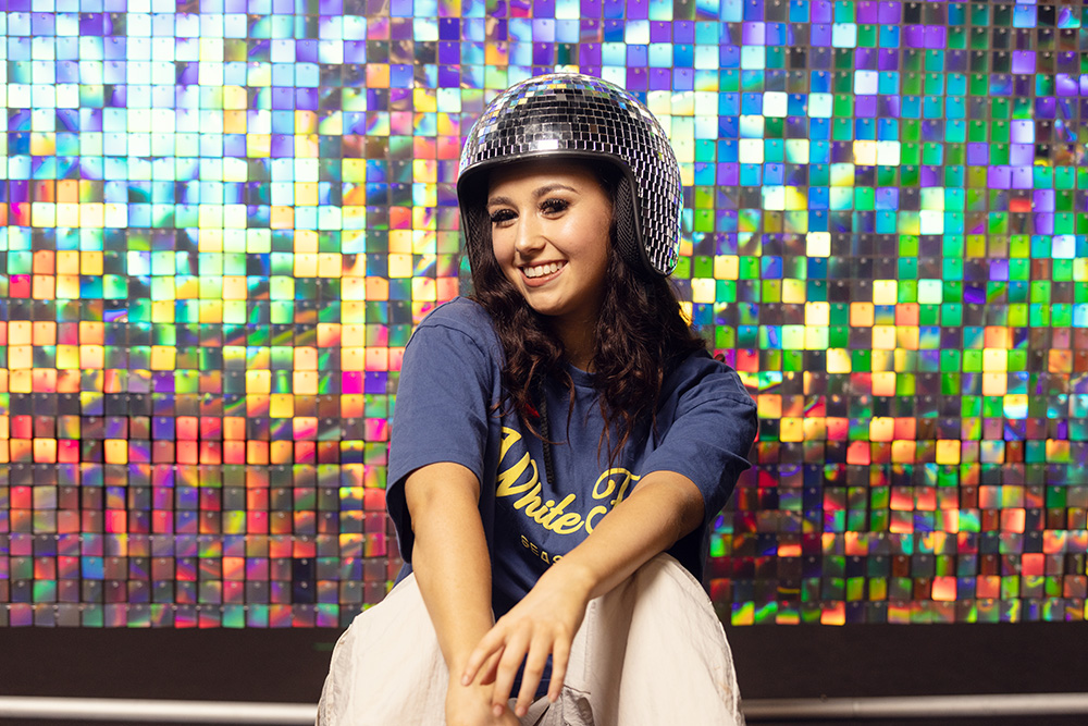 Gateshead Foundation College Student wearing a disco ball helmet infront of a shimmer backdrop