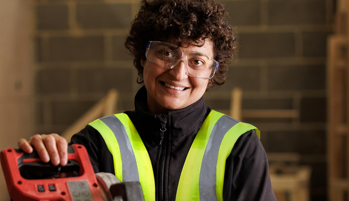 Construction apprentices wearing PPE smiling to camera